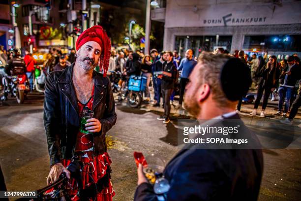 Man dressed as a woman for Purim speaks to an orthodox Jewish man after a shooting terror attack on Dizingof street. Palestinian militant group Hamas...
