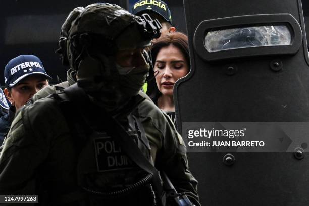 Colombian former Senator Aida Merlano is escorted by the police on her arrival to the Directorate of Criminal Investigation and Interpol office in...