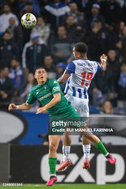 Estoril's Portuguese forward Tiago Gouveia and FC Porto's British forward Danny Namaso Loader jump for the ball during the Portuguese League football...