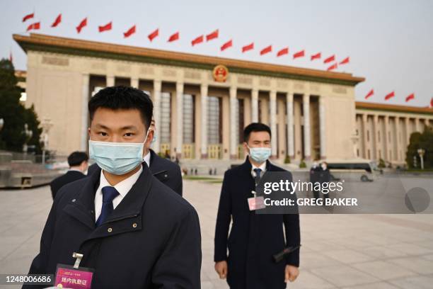 Security officers stand guard outside the Great Hall of the People ahead of the fourth plenary session of the National People's Congress at the Great...