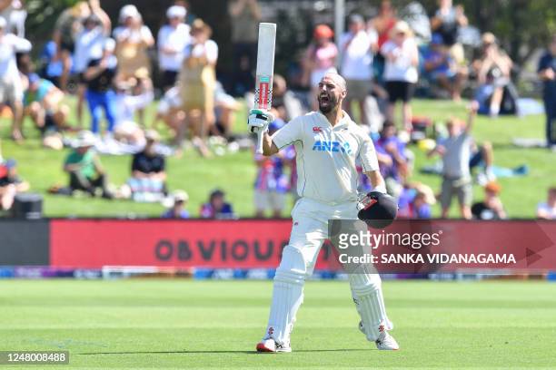 New Zealand's Daryl Mitchell celebrates after scoring 100 runs during the third day of the first Test cricket match between New Zealand and Sri Lanka...