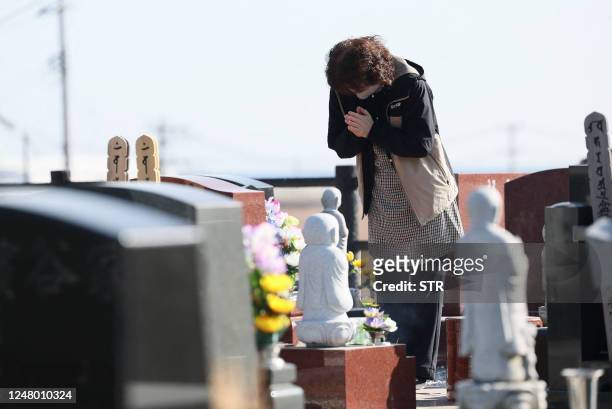 People visit a cemetery at Namie town of Fukushima Prefecture on March 11 on the 12th anniversary of the 9.0 magnitude earthquake which triggered a...