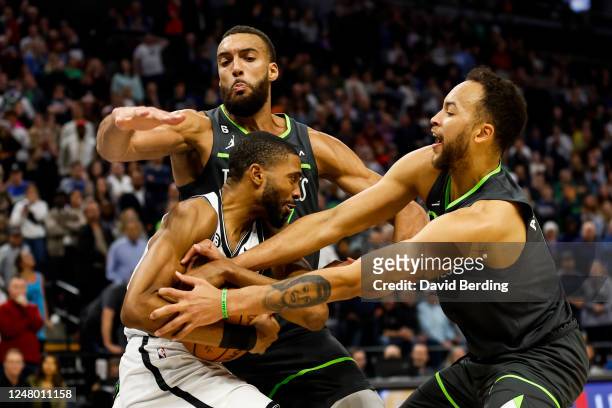 Mikal Bridges of the Brooklyn Nets is fouled by Kyle Anderson of the Minnesota Timberwolves while Rudy Gobert defends in the fourth quarter of the...