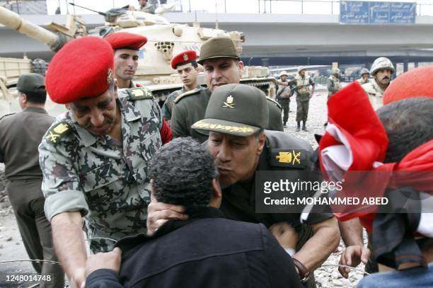 An Egyptian army general kisses anti-government protesters as he tries to convince them to move their barricades in Cairo's Tahrir square on February...
