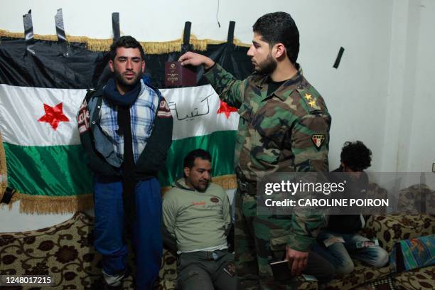 Defected Syrian soldier Abdel Razzaq Tlass of the Free Syrian Army holds the passport of one of five Iranians captured in the Baba Amr neighbourhood...