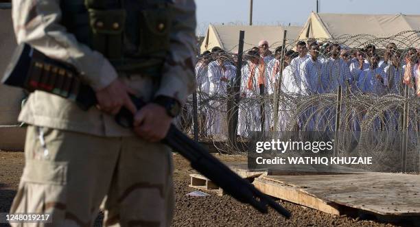 Soldier stands guard as Iraqi detainees wait to be released at Abu Ghraib prison 26 September 2005 in Abu Ghraib, 30 kms west of Baghdad. The US...