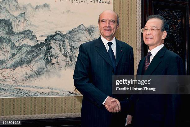 French Foreign Minister Alain Juppe shakes hands with Chinese Premier Wen Jiabao during their meeting at the Zhongnanhai leaders' compound on...