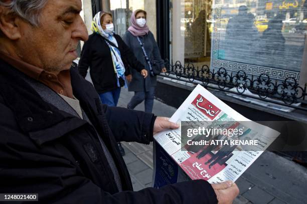 Man in Tehran holds a local newspaper reporting on its front page the China-brokered deal between Iran and Saudi Arabia to restore ties, signed in...