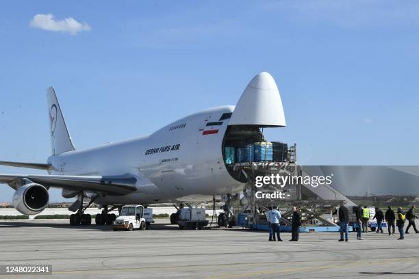 Employees unload humanitarian aid packages provided from Iran to earthquake victims off a Boeing 747-200 aircraft at Aleppo International Airport, a...