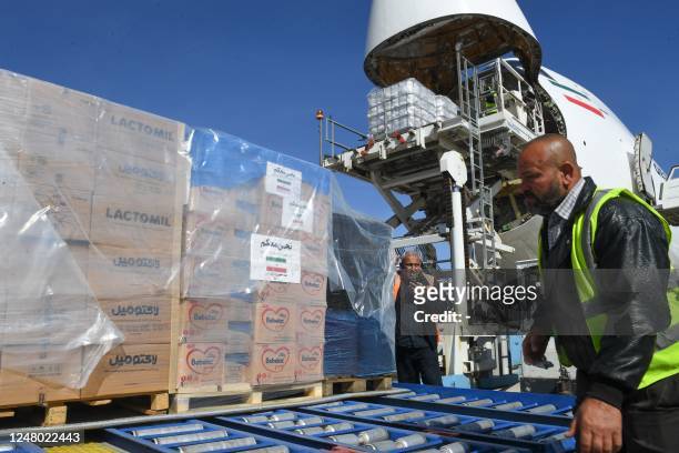 Employees unload an aircraft from Iran carrying aid to earthquake victims, at the Aleppo airport, a day after it reopened, on March 11, 2023. -...