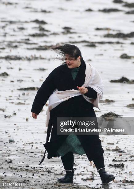 Woman struggles against the elements on Dollymount strand on a wet and windy day in Dublin. Picture date: Saturday March 11, 2023.