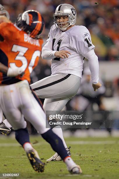 Place kicker Sebastian Janikowski of the Oakland Raiders kicks an extra point against the Denver Broncos at Sports Authority Field at Mile High on...