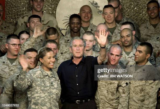 President George W. Bush waves to the crowd as he poses with Marines after speaking at Al-Asad Air Base in Anbar Province, Iraq, 03 September 2007....