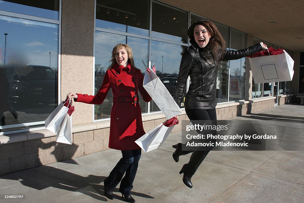 Two happy jumping shoppers