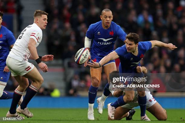 France's scrum-half Antoine Dupont offloads in the tackle during the Six Nations international rugby union match between England and France at...