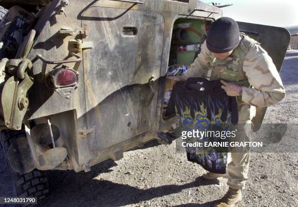 Lance Cpl Nick Bronte, of Pleasanton, California opens a Christmas present on Christmas Eve after mail call at the Kandahar airport, 24 December...