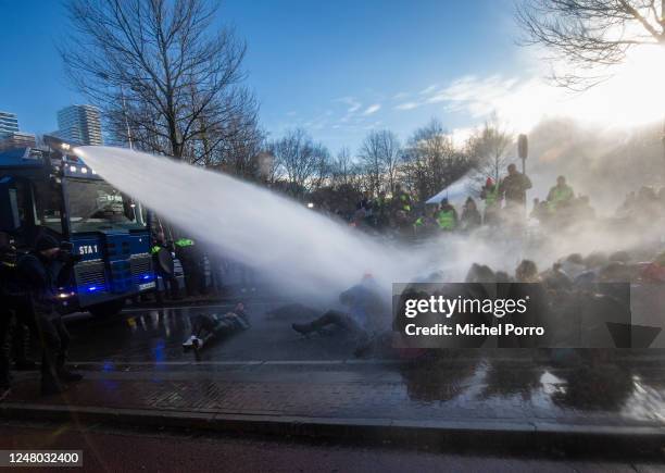 Police use a water canon after protesters blocked the A12 highway during an Extinction Rebellion protest on March 11, 2023 in The Hague, Netherlands....