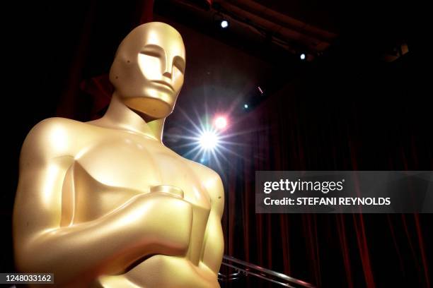 An Oscar statue stands on the red carpet as preparations are made ahead of the 95th Academy Awards, in Hollywood, California, on March 11, 2023. -...