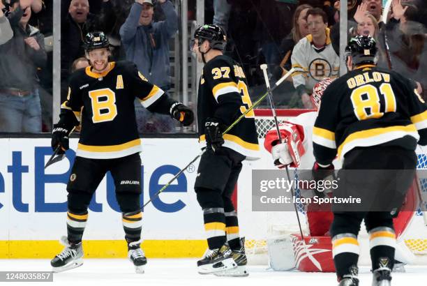 Boston Bruins right wing David Pastrnak congratulates Patrice Bergeron during a game between the Boston Bruins and the Detroit Red Wings on March 11...