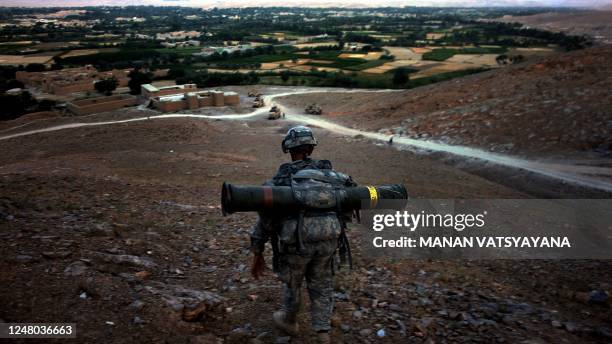 Soldier from the 1st Platoon Alpha 3-71 cavalry carries a TOW missile as he walks downhill from an outpost in the Baraki Barak district of Logar...