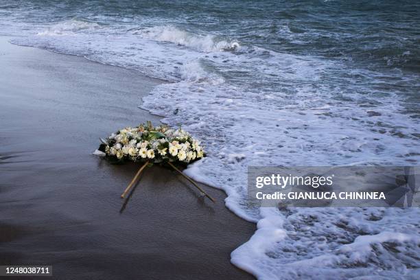 Wreath of flowers floats on the Mediterranean Sea, thrown by people who ended a protest march on the beach at the site of the shipwreck on March 11,...