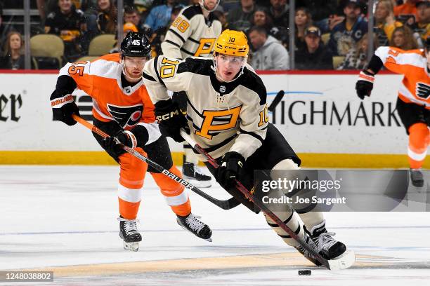 Drew O'Connor of the Pittsburgh Penguins skates against Cam York of the Philadelphia Flyers at PPG PAINTS Arena on March 11, 2023 in Pittsburgh,...