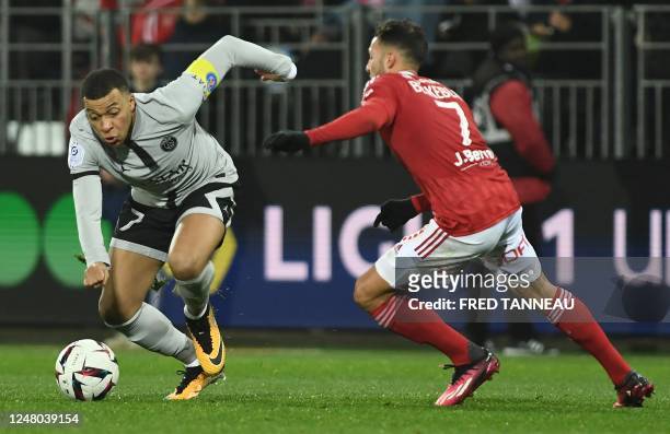 Paris Saint-Germain's French forward Kylian Mbappe fights for the ball with Brest's Algerian midfielder Haris Belkebla during the French L1 football...