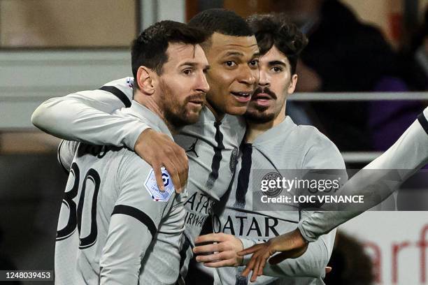 Paris Saint-Germain's French forward Kylian Mbappe is congratulated by teammates after scoring a goal during the French L1 football match between...