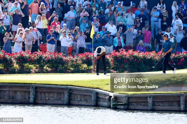 Golfer Aaron Rai pulls the ball from the cup after making a hole in one on the 17th hole on March 11 during the third round for THE PLAYERS...