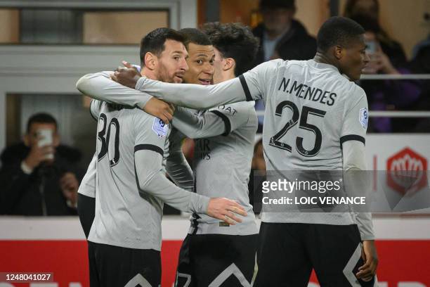 Paris Saint-Germain's French forward Kylian Mbappe is congratulated by teammates after scoring a goal during the French L1 football match between...