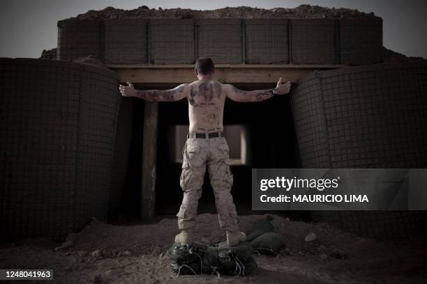 3rd Battalion, 6th Marines, Staff Sergeant Bobby Stone of Hatfield, Arizona, poses to show his tattoos, including the inscription 'All Gave Some,...