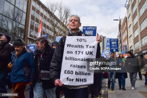 Activist Peter Tatchell holds a placard calling for a wealth tax on billionaires to fund the NHS, during the demonstration in Tottenham Court Road....