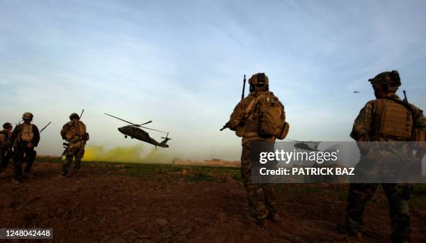 Army special forces stand guard as Blackhawk helicopter transporting NATO officers land in Marjah's Balakino Bazar neighborhood on February 24, 2010....