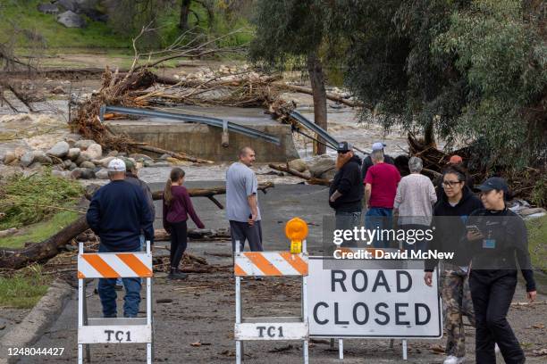 People view the wreckage of a bridge over the Tule River that was destroyed in a flash flood on March 10, 2023 near Springville, California. Another...