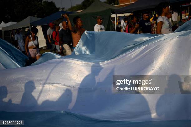 Faithfuls hold an Argertine national flag as they march towards the Basilica of Lujan on March 11 in Lujan, Buenos Aires province, to participate in...