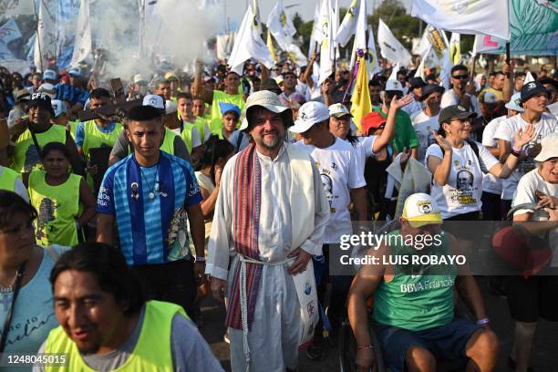 Father Jose "Pepe" Di Paola and faithfuls march towards the Basilica of Lujan on March 11 in Lujan, Buenos Aires province, to participate in a mass...