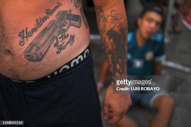 Faithful with a tattoo of a gun attends a mass in front of the Basilica of Lujan on March 11 in Lujan, Buenos Aires province, Argentina, to celebrate...