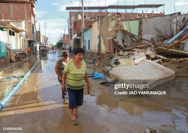 Residents walk among devastated neigborhoods and homes of the semi rural district of Illimo in the Piura region in northern Peru, on March 11 after...