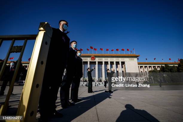 Security personnel stand guard at Tiananmen Square during the fifth plenary meeting of the first session of the 14th National People's Congress on...