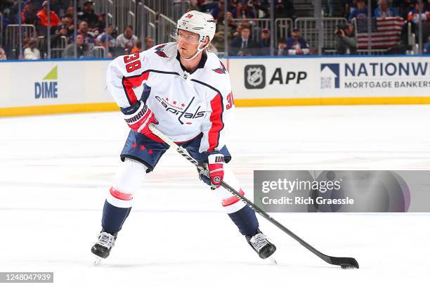 Rasmus Sandin of the Washington Capitals handles the puck against the New York Islanders during the second period at UBS Arena on March 11, 2023 in...