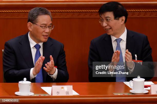 Chinese Premier Li Qiang speaks with Wang Huning during the fifth plenary session of the National People's Congress on March 12, 2023 in Beijing,...