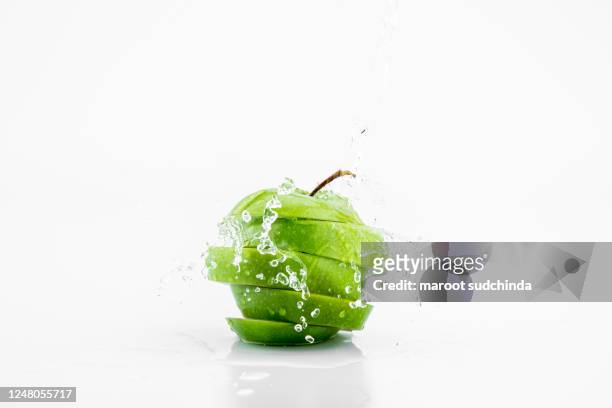 green apple water splashing with its fruits isolated on white background - apple water splashing stock pictures, royalty-free photos & images