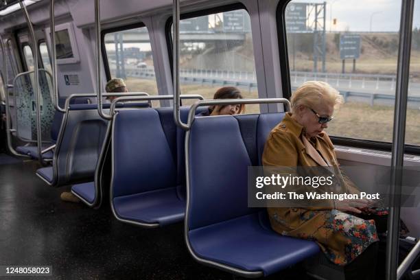 Passengers heading in the direction of Washington, D.C. Sit far apart from each other departing the recently opened Dulles Airport station along the...