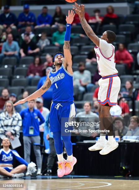 Bradley forward Ja'Shon Henry attempts a three point shot as Drake guard Roman Penn defends during a game between the Drake Bulldogs and the Bradley...