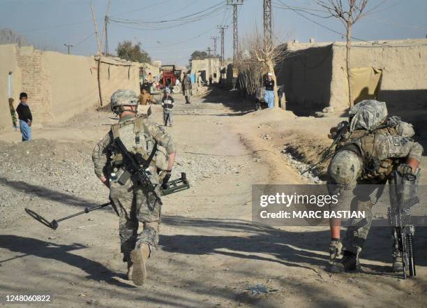 Soldiers from 1st Batallion, 66 Armored Regiment, 1st Brigade Combat Team Task Force Raider search for Improvised Explosive Devices in a street in...