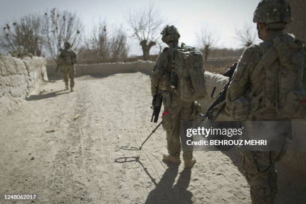 Private Timothy Goldsmith from 1-320 Field Artillery Regiment, 2nd Brigade Combat, 101st Airborne Division uses a mine detector device as he searches...