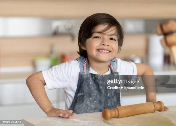 gelukkige jongen die pret heeft die thuis kookt en een knoeit maakt - apron isolated stockfoto's en -beelden