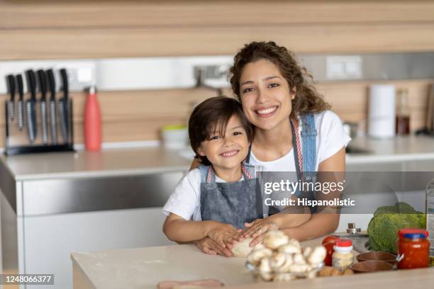 loving mother and son making pizza at home - kid chef stock pictures, royalty-free photos & images