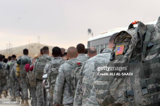 Army soldiers queue to board a plane to begin their journey home out of Iraq from the al-Asad Air Base west the capital Baghdad, on November 1, 2011....