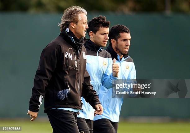 Manchester City manager Roberto Mancini with Carlos Tevez and Sergio Auero during a training session at Carrington Training Ground on September 13,...